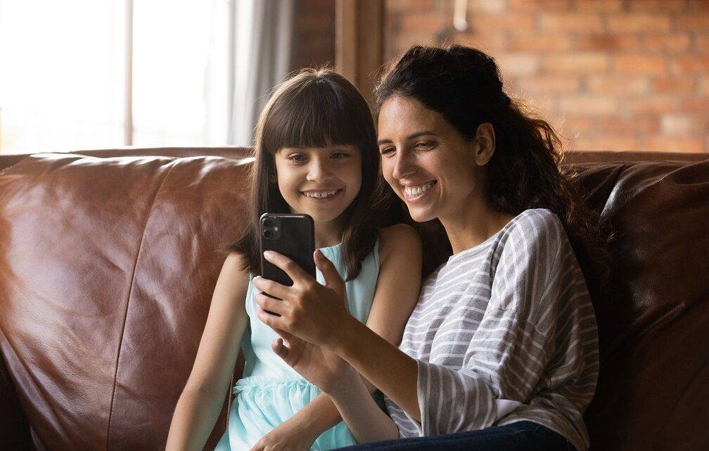 Mama und Tochter telefonieren gemeinsam mit anderen Person per Videocall