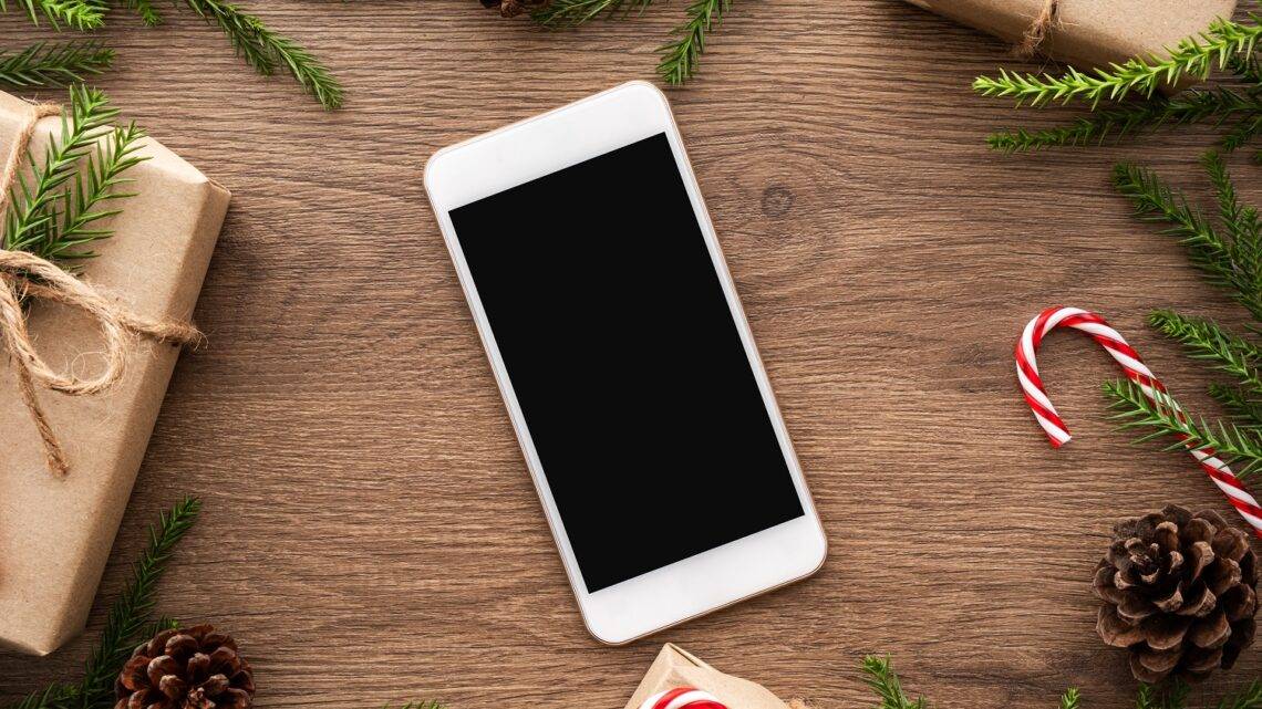 neues Smartphone auf einem weihnachtlich gedeckten Tisch