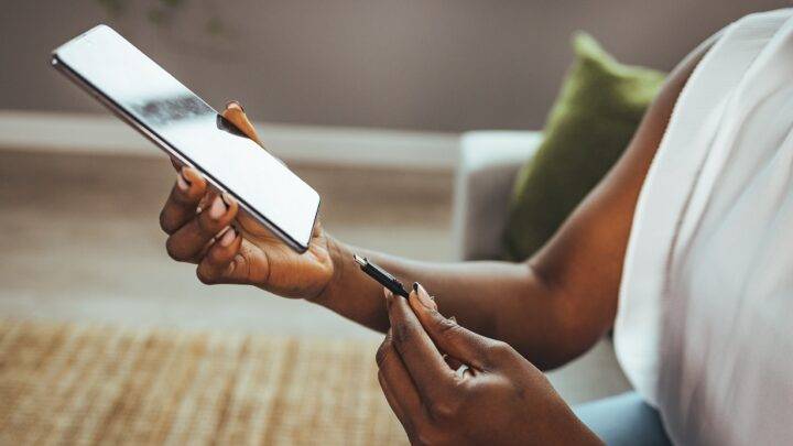Frau steckt Ladekabel in Smartphone