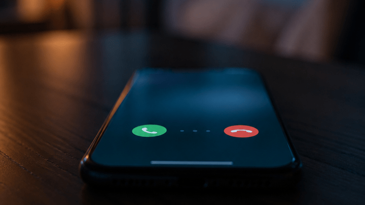 Symbolbild: Smartphone zeigt eingehenden Anruf mit 0208 Vorwahl in dämmriger Umgebung